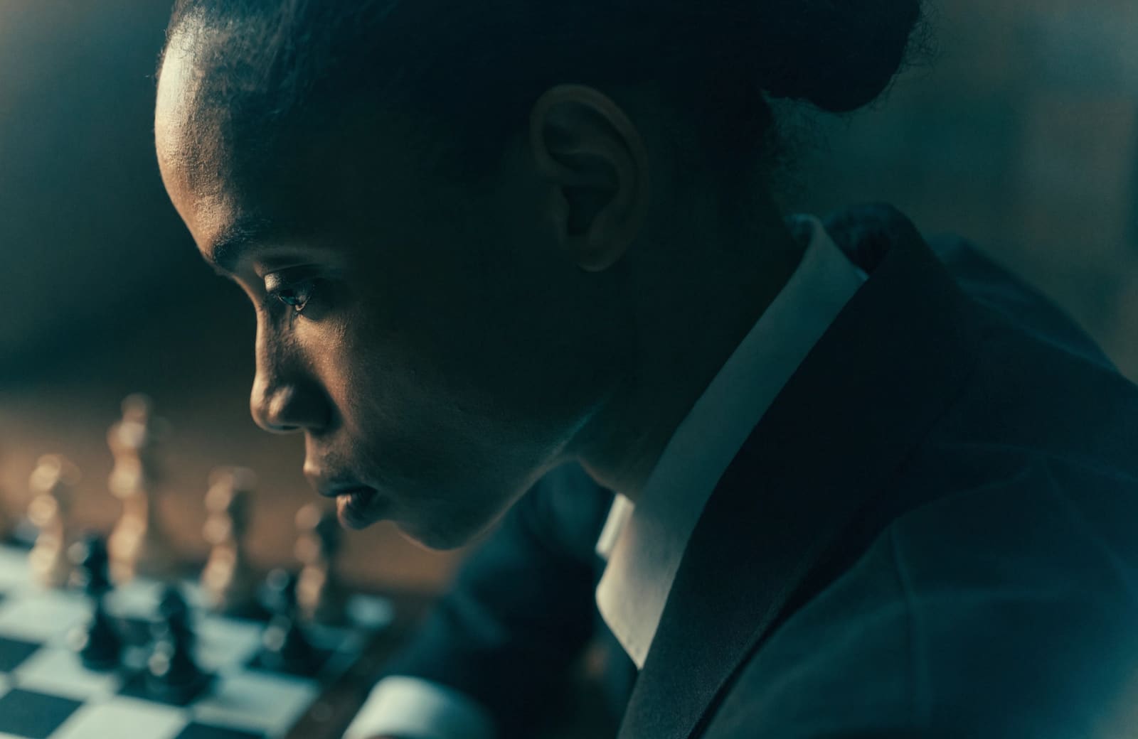 A focused competitor composed before a move, warm rim light, cool shadows.